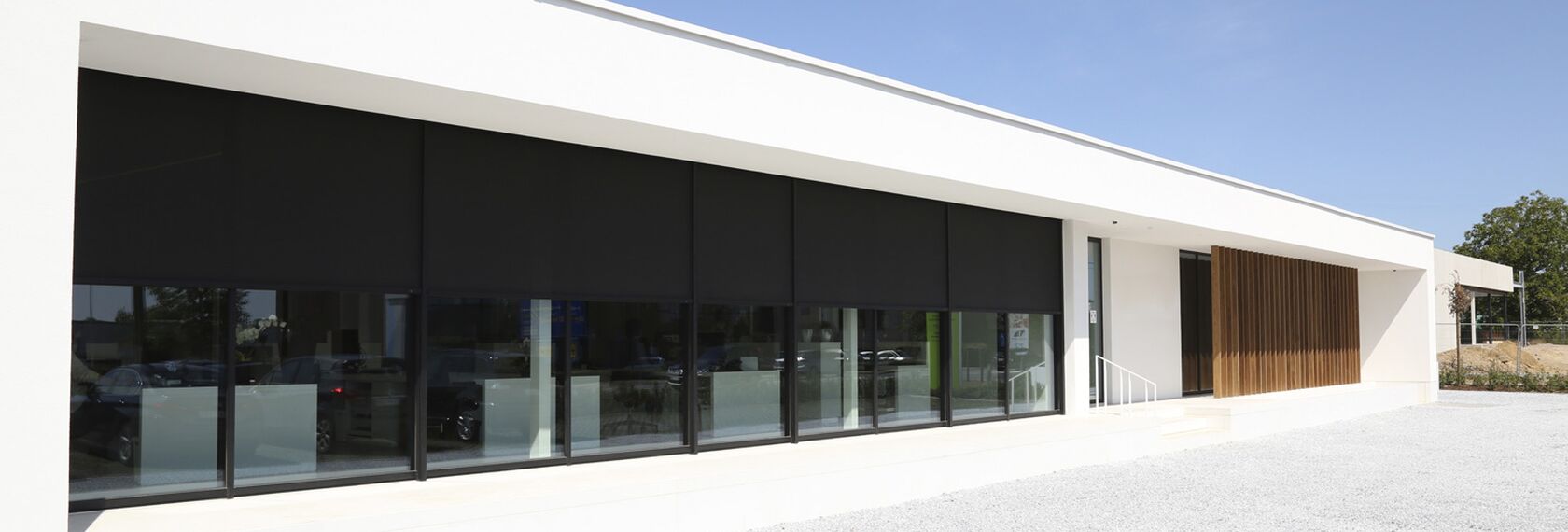 Modern white office building featuring Renson Fixscreen solutions.