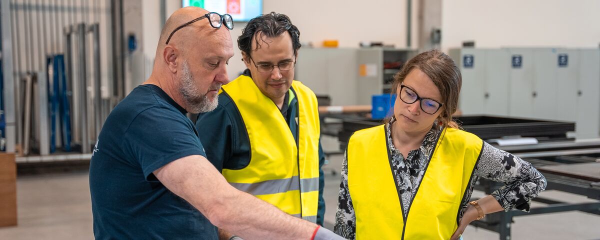 Fabricator discussing order details with two building professionals.